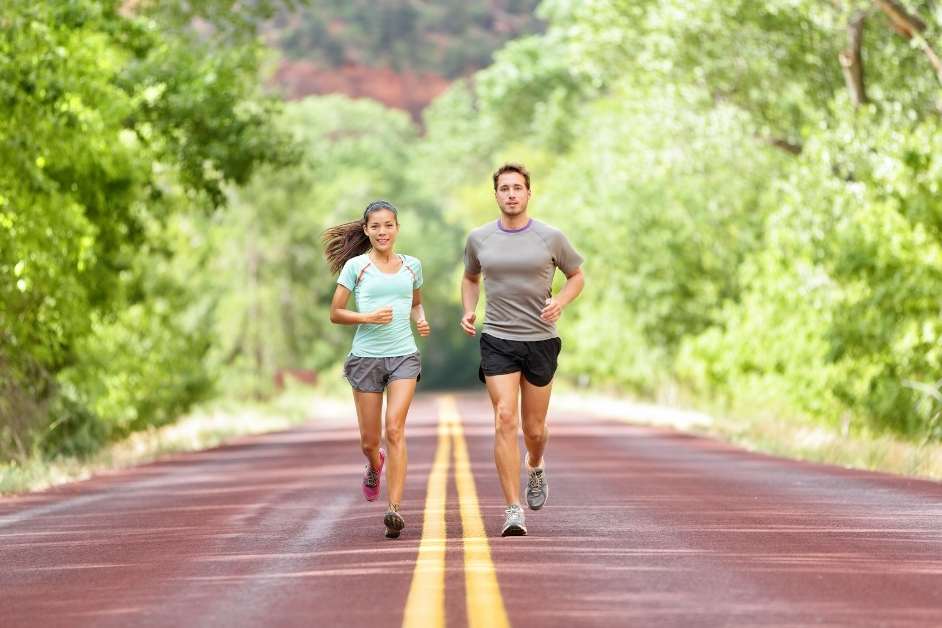 Man and woman running together on road