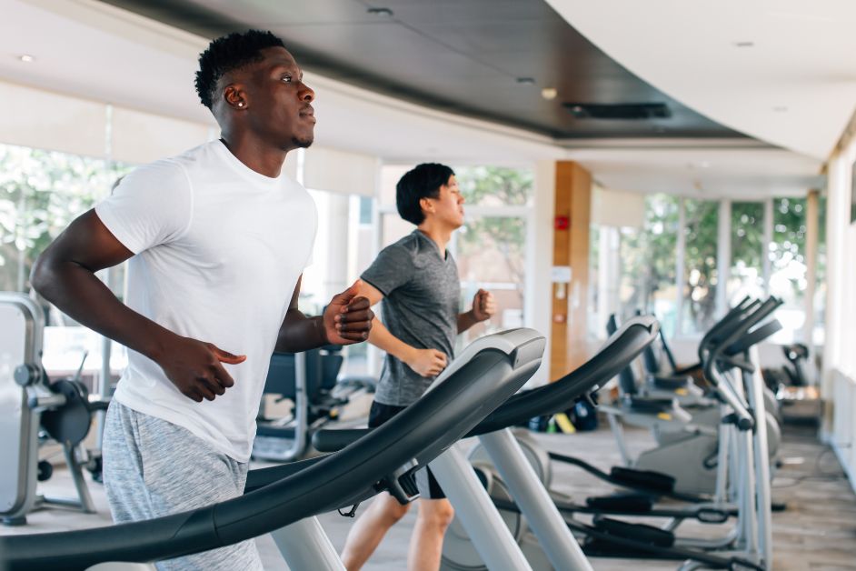 Two men running on treadmills.